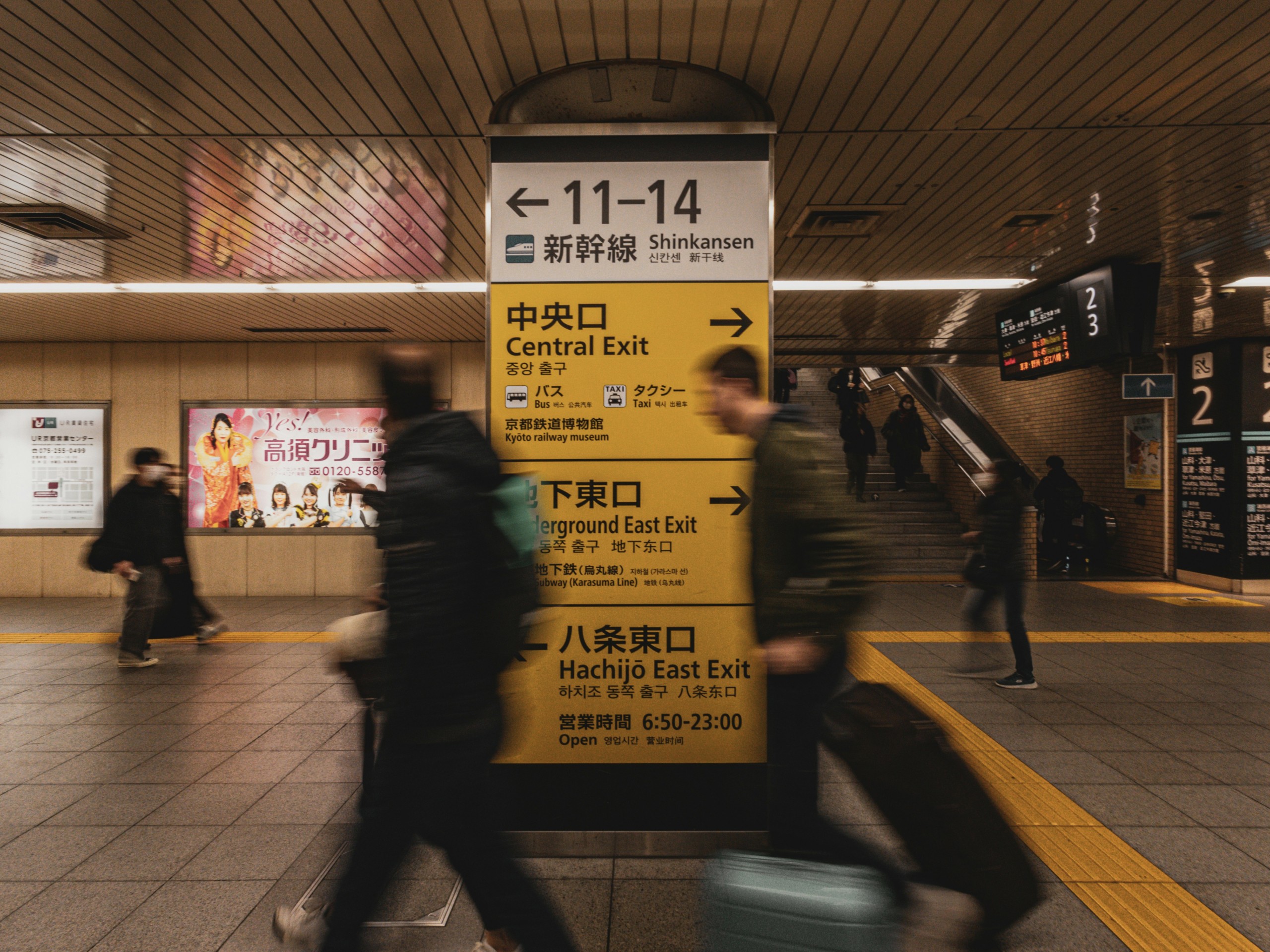 日本の駅改札で人々が行き交う中、Suicaの高速処理と判断の場所を象徴する案内サイン